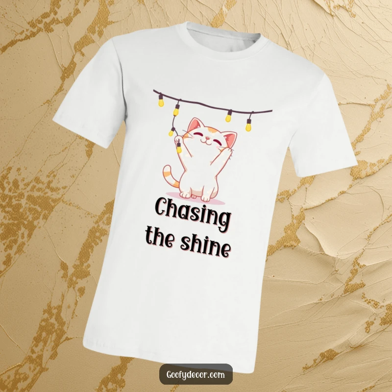 Funny t-shirt showing a mischievous cat character intently batting at a tempting string of brightly twinkling lights.