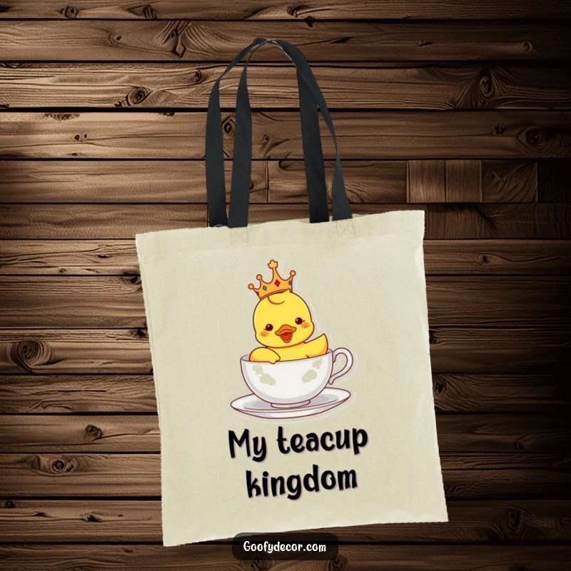 Funny tote bag featuring a crowned rubber ducky sailing in a teacup, perfect for carrying essentials with a royal and whimsical touch.